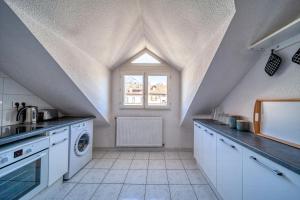 a kitchen with white cabinets and a window at Le Reverso, T6 en duplex & vue incroyable in Grenoble +4 photos