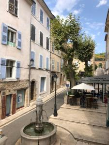 a fountain in the middle of a street with buildings at fontaine in Aups
