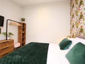 ein Schlafzimmer mit einem Bett mit einer grünen Bettdecke in der Unterkunft The Holgate Snug in York