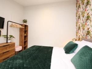 a bedroom with a bed with a green comforter at The Holgate Snug in York