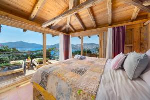 a bedroom with a bed and large windows at Fidanka Hotel in Kalkan