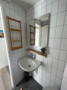 a white bathroom with a sink and a mirror at Juna in Laboe