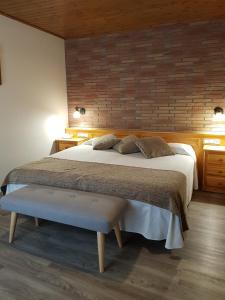 a bedroom with a large bed and a brick wall at Hotel Sant Roc in Camprodon