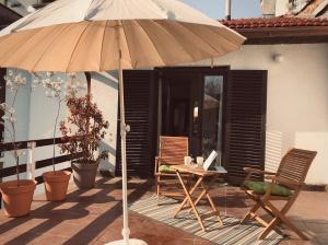 a patio with an umbrella and a table and chairs at MonikaRooms in Zagreb