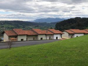 eine Reihe von Häusern mit roten Dächern auf einem Hügel in der Unterkunft Apartamentos Monterodiles in Liñero