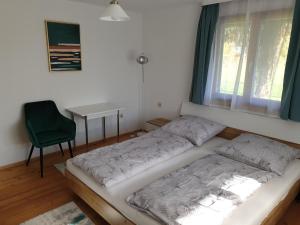 een bed in een kamer met een raam en een bureau bij Ferienwohnung Suppan in Hörbranz