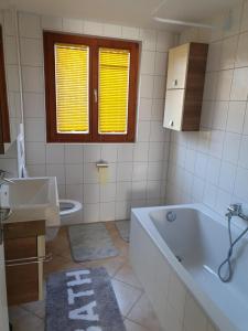 a bathroom with a tub and a sink and a toilet at Ferienwohnung Suppan in Hörbranz