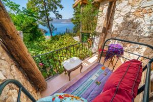 a balcony with a bench and a view of the ocean at Fidanka Hotel in Kalkan