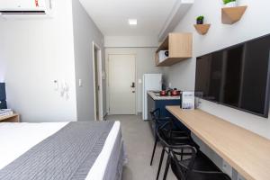 um quarto com uma cama e uma secretária com uma televisão em 360 Brooklin em São Paulo