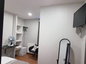 a bedroom with a bed and a desk and a tv at Hameau des Essarts in Grand-Couronne