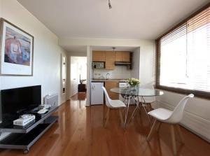 cocina y sala de estar con mesa y sillas en Providencia Pedro de Valdivia 0200, en Santiago