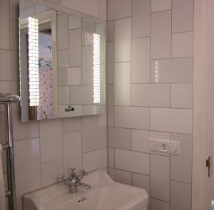 een witte badkamer met een wastafel en een spiegel bij Rosalia's Menagerie Cocktail bar & InnUpstairs in Amsterdam +32 foto's