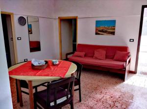 a living room with a red couch and a table at Belvedere in Pantelleria