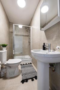 a bathroom with a sink and a toilet and a shower at Modern 2 Bed Apartment with Balcony in Stockport Centre by Hass Haus in Stockport