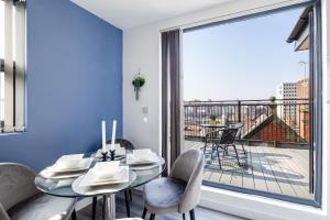 a dining room with a table and chairs and a large window at Top Floor Apartment with Private Balcony in Stockport Centre by HASS HAUS in Stockport