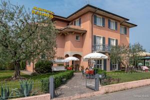 a large pink building with umbrellas in front of it at Albergo Bagner in Sirmione