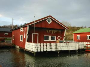 una casa roja en un muelle en el agua en Havgløtt, en Rabben