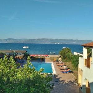 een uitzicht op een resort met een zwembad en de oceaan bij Sofia Beach Apartments in Kavos