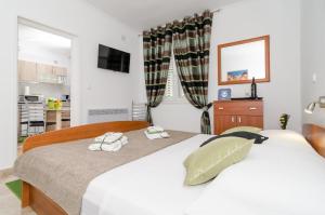 1 dormitorio con 1 cama grande y 2 toallas en Apartment and Room Kapelica, en Dubrovnik
