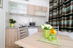 a kitchen with a table with flowers and oranges on it at Apartment and Room Kapelica in Dubrovnik