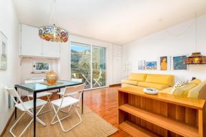 a living room with a table and a yellow couch at Rossi Tramonti 2, Terre Marine in Corniglia