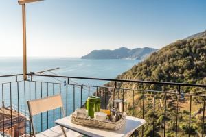 a table on a balcony with a view of the ocean at Rossi Tramonti 2, Terre Marine in Corniglia