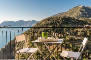 a table and chairs on a balcony overlooking the mountains at Rossi Tramonti 2, Terre Marine in Corniglia