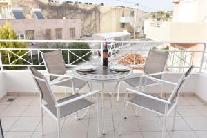 a white table and chairs on a balcony at Casa de Campo 2 in Almyrida