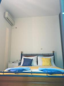 a bed with blue and yellow pillows on it at Serifos Palace in Livadakia