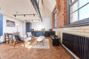 a living room with a couch and a brick wall at No 6 at Simpson Street Apartments Sunderland in Sunderland