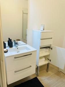 a bathroom with a white sink and a mirror at Appartement 3 chambres in Vitry-sur-Seine