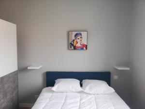 HOTEL VILLA SOL في بيسكاروس: غرفة نوم بسرير مع لوحة على الحائط