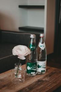 two coke bottles on a wooden table with a flower at Winkel Art Hotel in Gamlitz