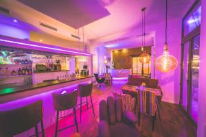 a bar with purple lighting in a restaurant at Hotel via City Leipzig Mitte in Leipzig