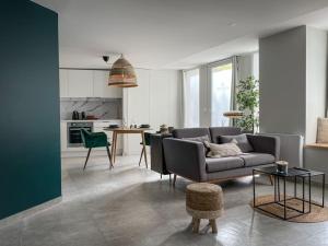 ein Wohnzimmer mit einem Sofa und einer Küche in der Unterkunft SUITE AMANTIS évadez vous dans l'univers MYKONOS in Saint-Chamond