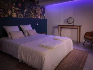 ein Schlafzimmer mit einem großen Bett mit Handtüchern darauf in der Unterkunft SUITE AMANTIS évadez vous dans l'univers MYKONOS in Saint-Chamond