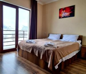 グダウリにあるGudauri Guest House Laneのベッドとタオル2枚のある寝室