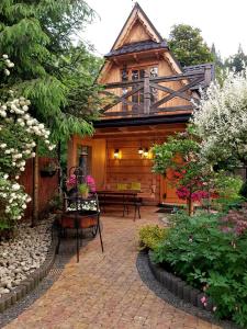 a wooden house with a porch and a patio at Domek Góralski Chatka Puchatka in Poronin