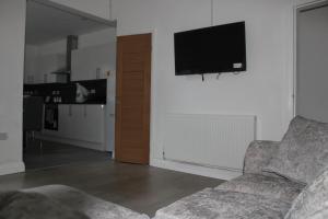 sala de estar con sofá y TV de pantalla plana en Beautiful, Spacious, Old Trafford home en Mánchester
