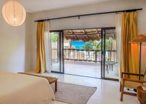 a bedroom with a bed and a view of the ocean at Dune Boutique Hotel located at the party zone in Tulum