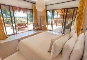 a bedroom with a large bed and large windows at Dune Boutique Hotel located at the party zone in Tulum