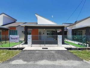 uma casa com um portão em frente em Nawra Homestay Besut, Terengganu em Kampung Raja
