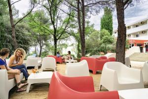 un restaurante con sillas rojas y blancas en Belambra Clubs Résidence Le Pradet - Lou Pigno, en Le Pradet