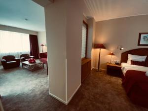 una camera d'albergo con letto e soggiorno di Hotel Memling a Kinshasa
