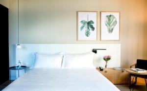 サン・セバスティアンにあるHotel Arima & Spa - Small Luxury Hotelsの白いベッド1台、壁に2枚の写真が飾られたベッドルーム1室