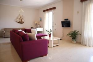 sala de estar con sofá púrpura y mesa en Helena Apartment Argostoli, en Argostoli