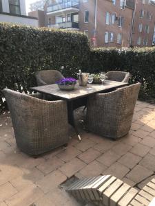 een tafel met rieten stoelen en een tafel met bloemen erop bij Casa 1-2-3 in Zandvoort