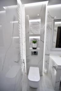 a white bathroom with a toilet and a sink at Bourbon Boutique Hotel in Yerevan