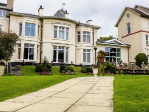 a large house with a green lawn and a sidewalk at The Devonshire House Hotel-Free Parking in Liverpool