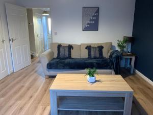 uma sala de estar com um sofá e uma mesa em Kirkby House, 3 bedroom, sleeps up to 7 with sofa bed, holiday, corporate, contractor stays em Kirkby in Ashfield